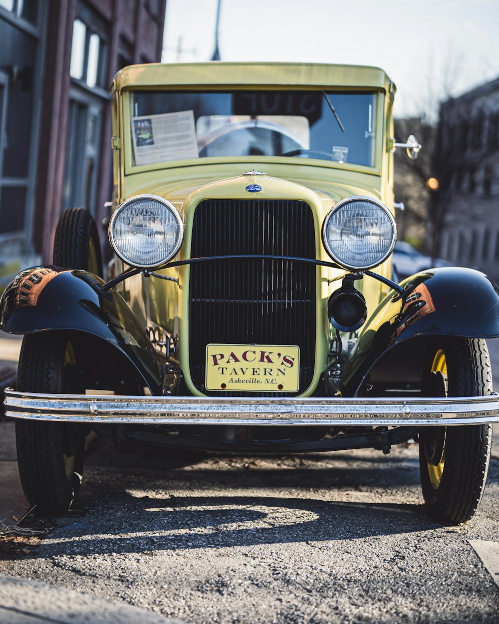 a yellow car parked on the side of a road