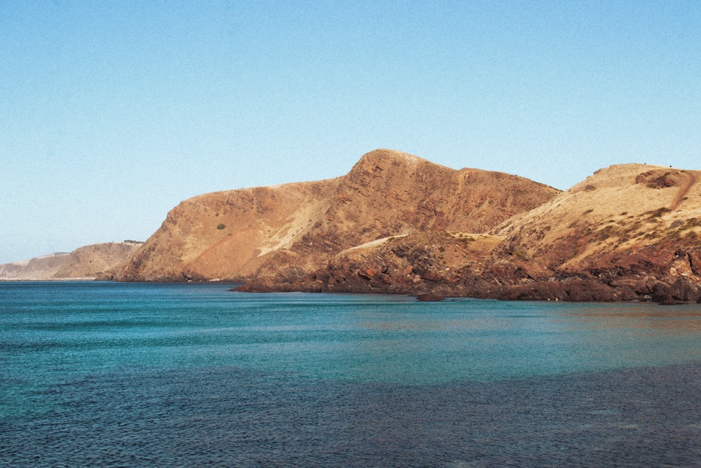 a body of water with a mountain in the background