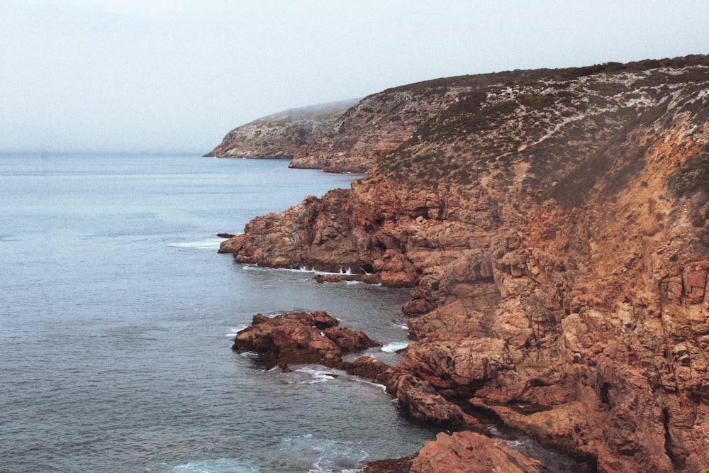 a rocky cliff next to the ocean