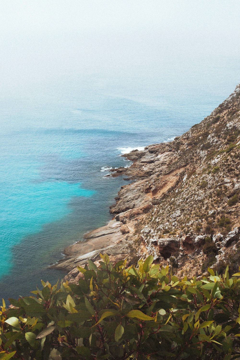 a rocky cliff overlooking a body of water