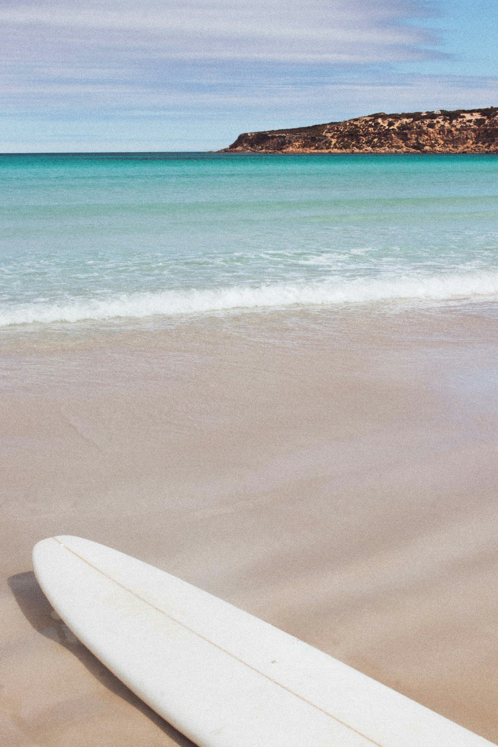 a white surfboard on a beach