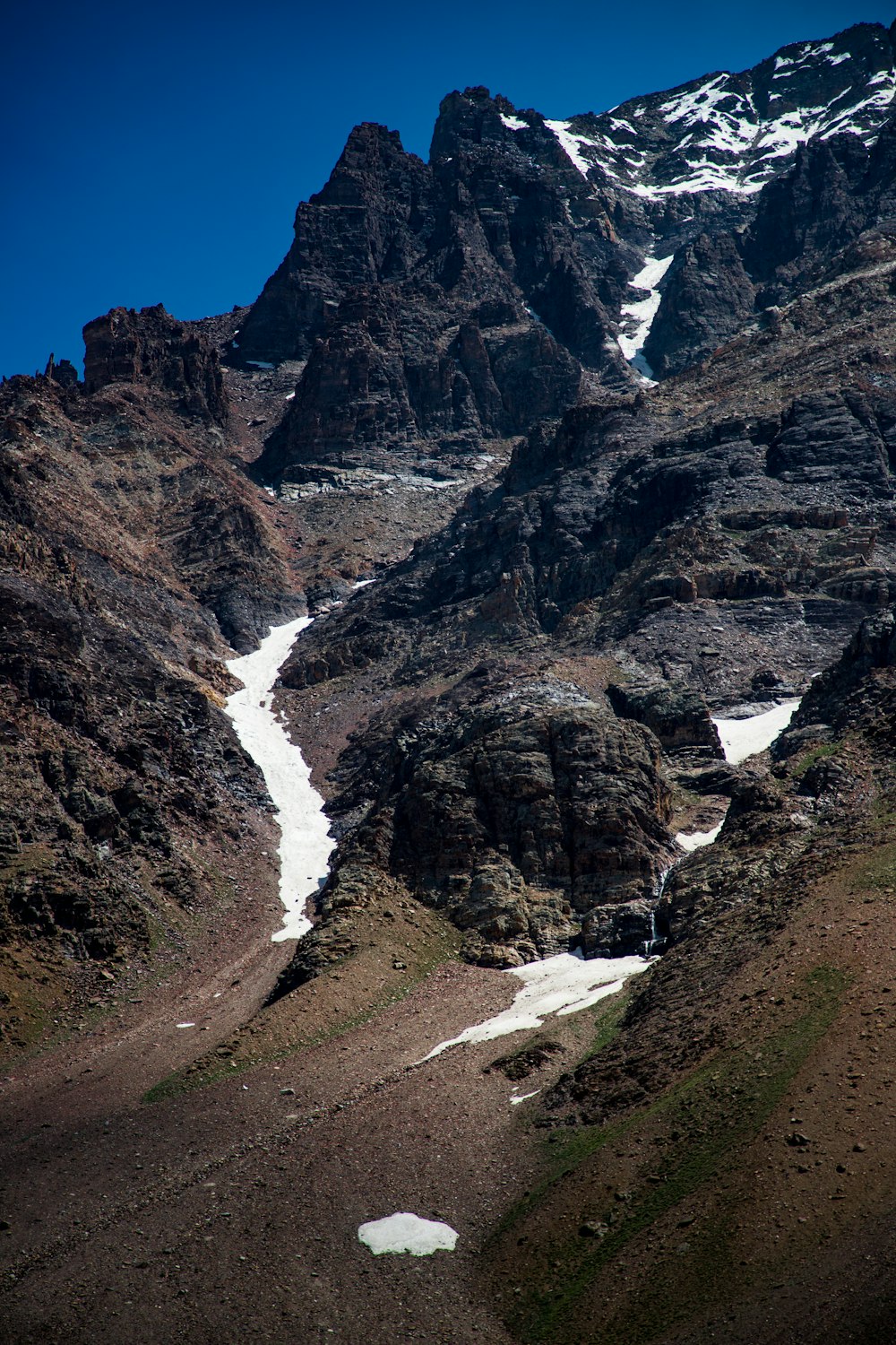 a rocky mountain with a stream running through it