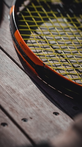 Detailed shot of the handrills wheels and rail mechanism attached to a tennis racket during a training session.