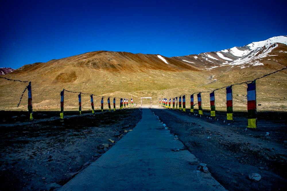 a road with a fence and a mountain in the background