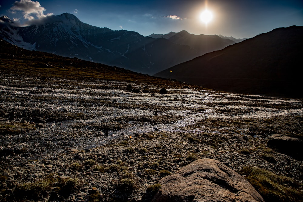 a rocky landscape with mountains in the background