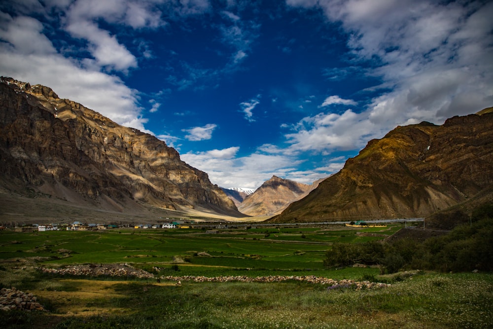 a landscape with mountains and grass