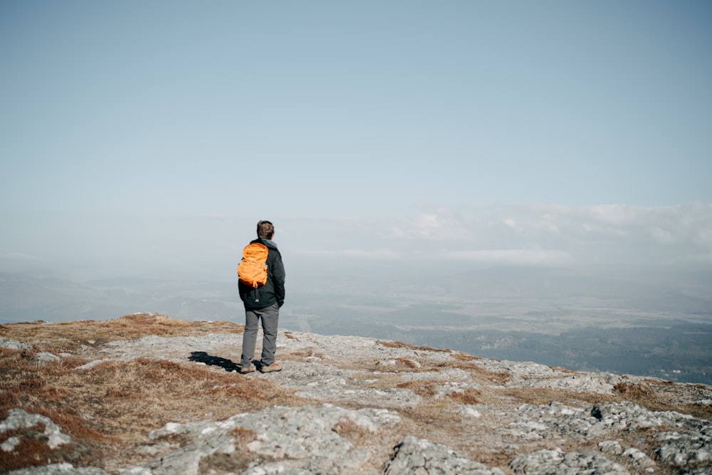 a man standing on a rocky hill