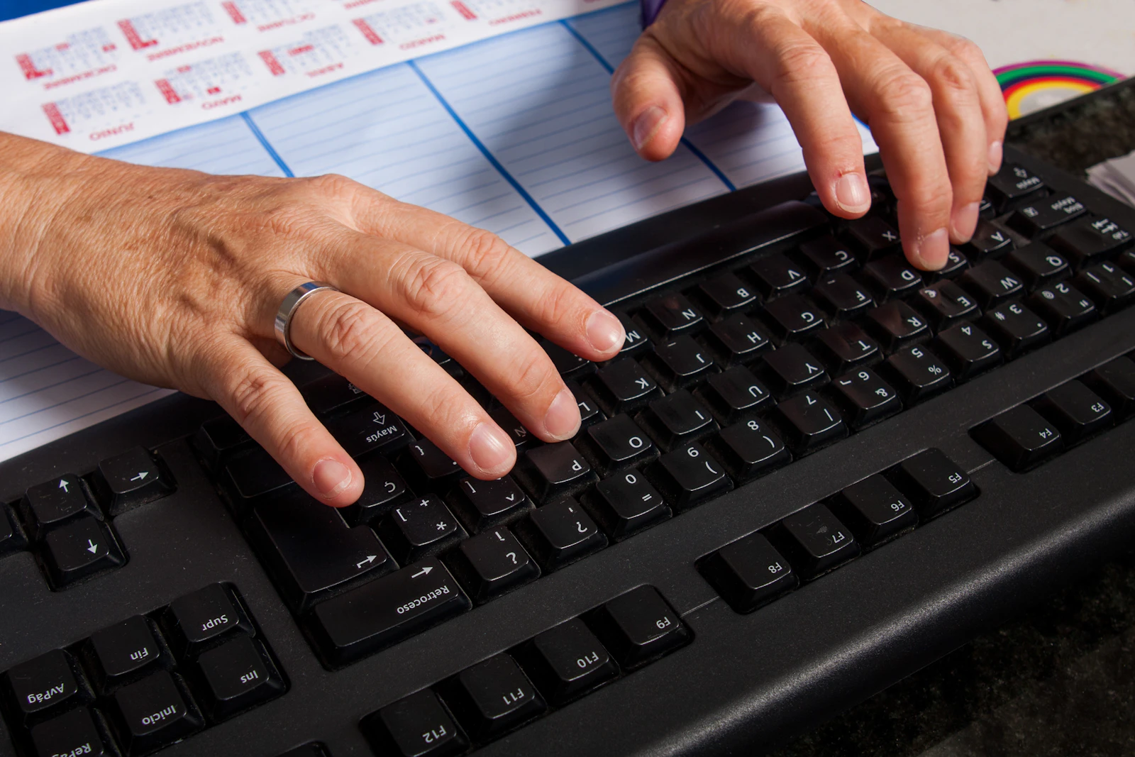 Hands typing on a laptop at a focused study desk