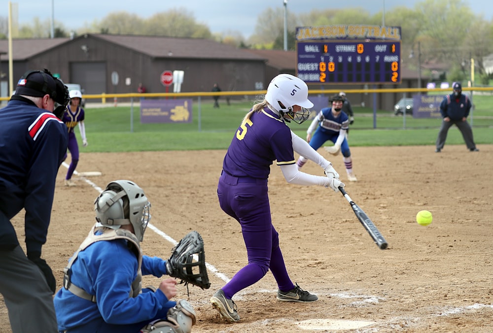 a person hitting a ball with a baseball bat