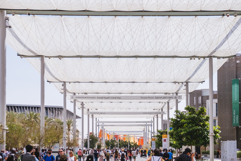 a large group of people walking under a covered area