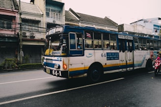 A 25-seat Rosa bus driving past iconic Sydney landmarks on a sunny day.