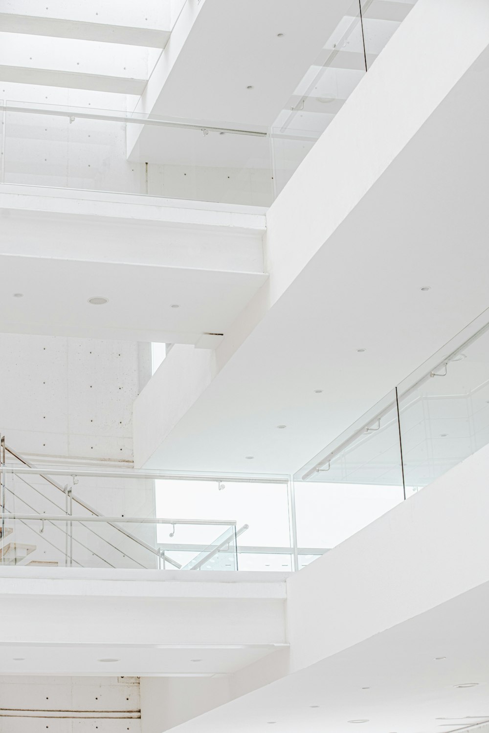 a white staircase with glass railings