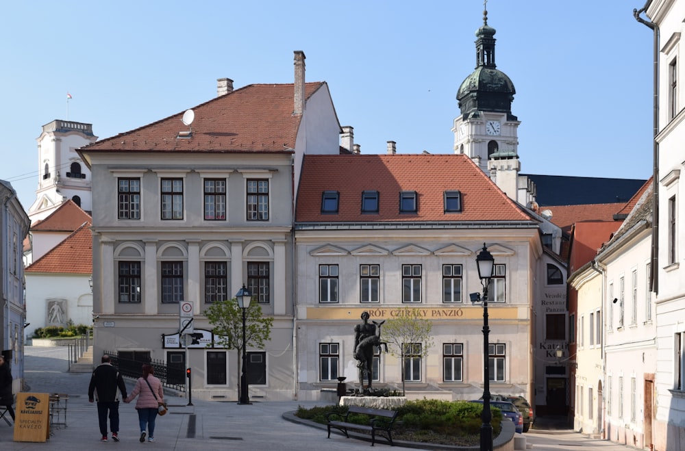 a group of people walking on a street between buildings