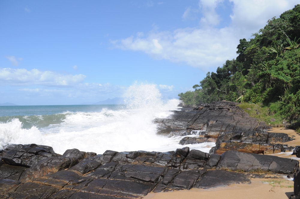 uma praia rochosa com ondas batendo