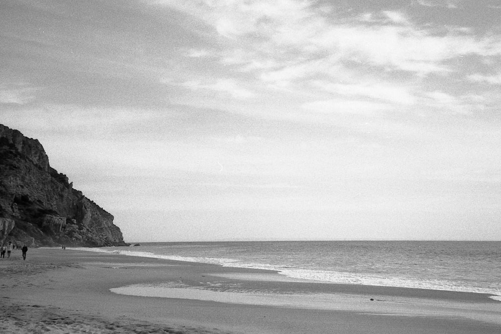 a beach with people walking on it