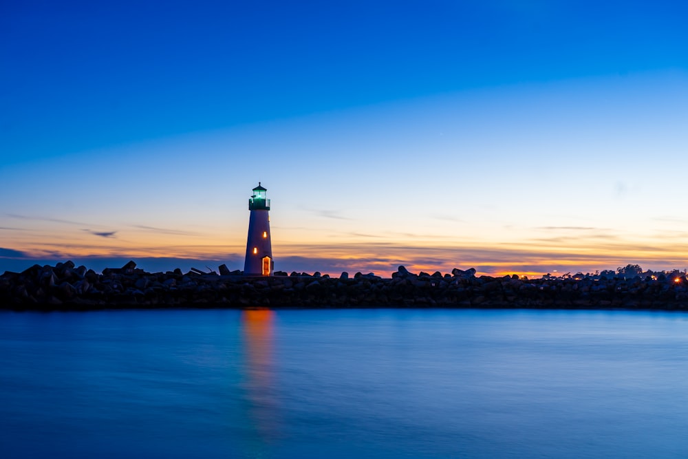 a lighthouse on a hill by the water