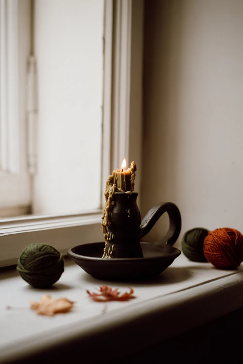 Warm candlelight on a minimalist bedside table