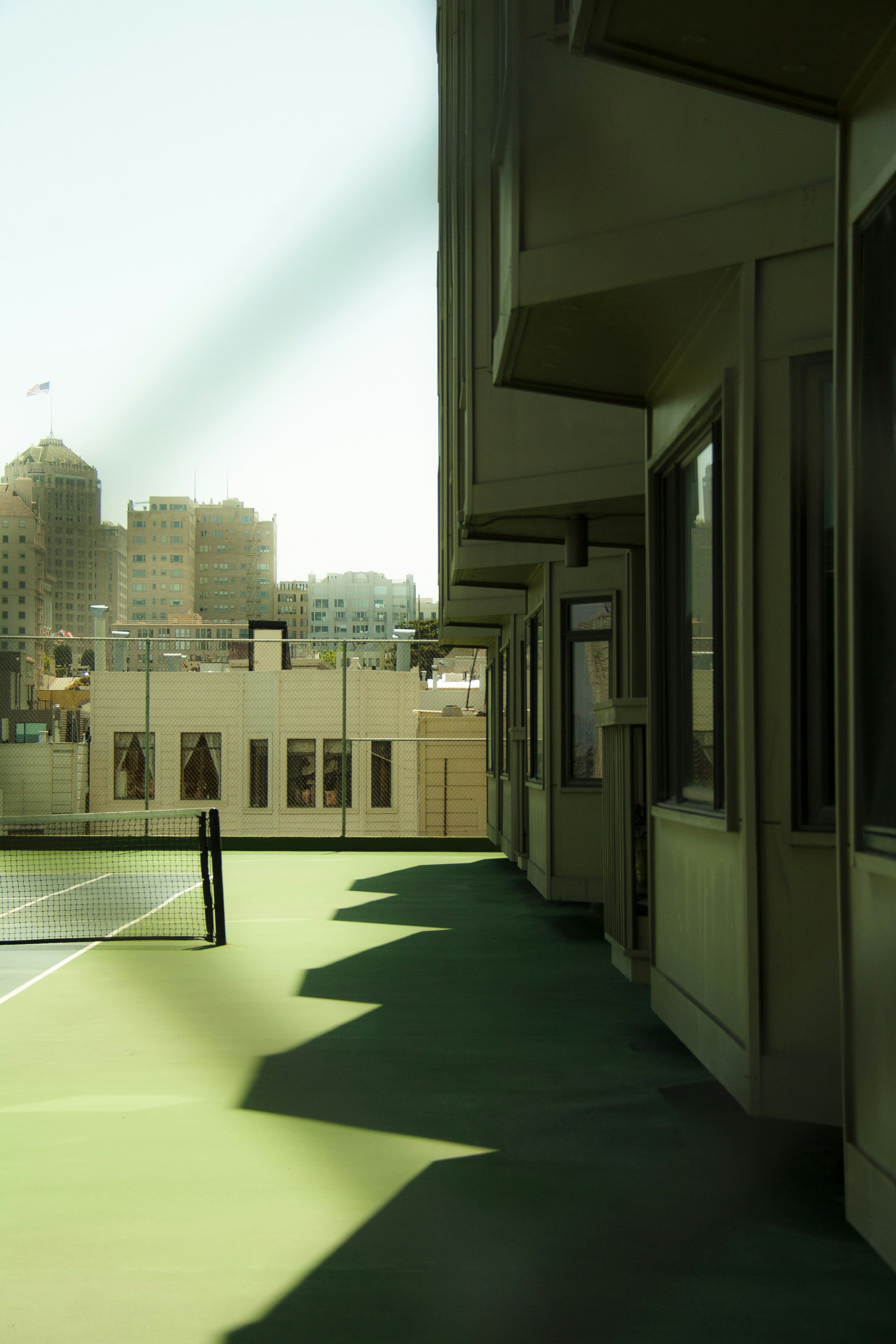 a building with a fence and a tennis court