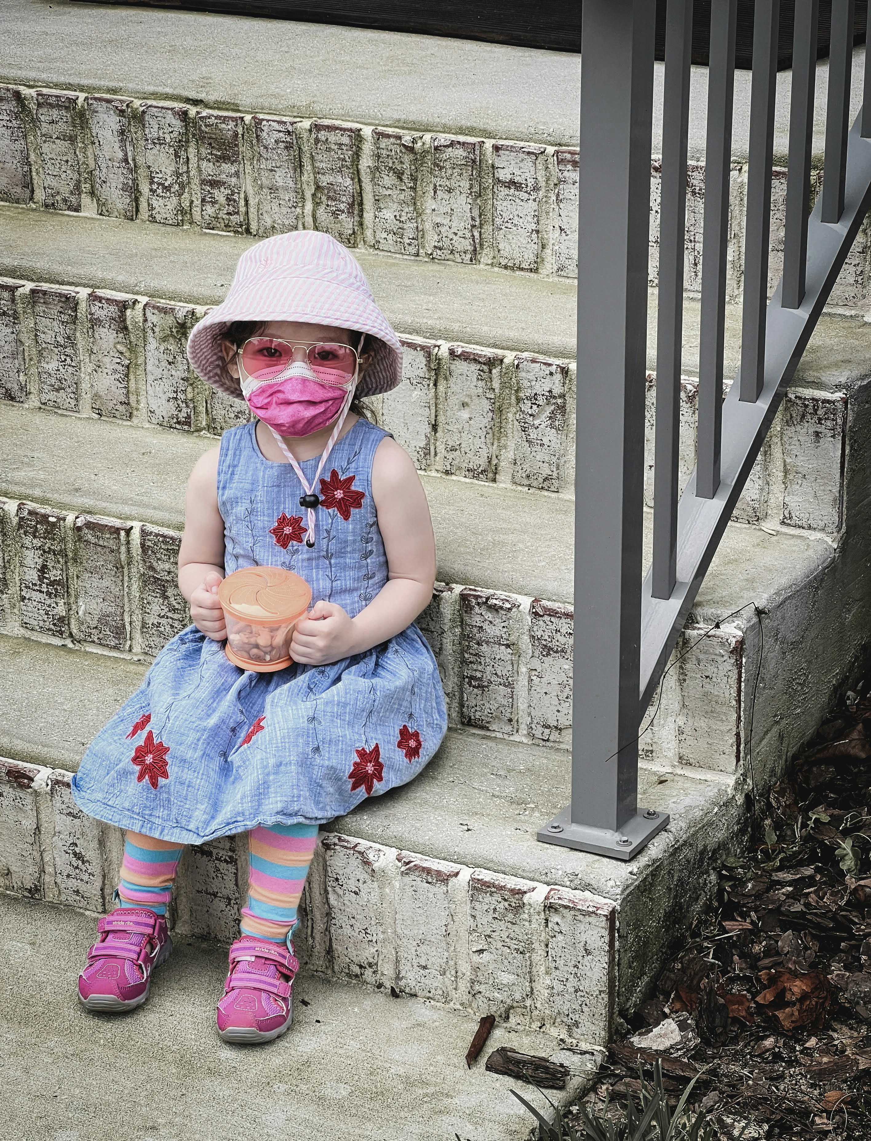 a child wearing a mask and holding a cup