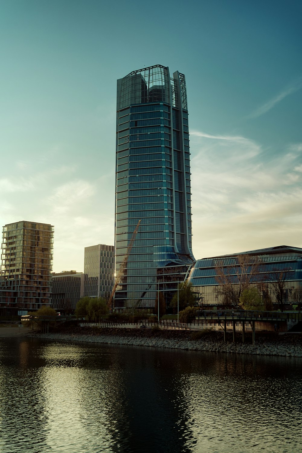 a tall glass building by a river with Millbank Tower in the background