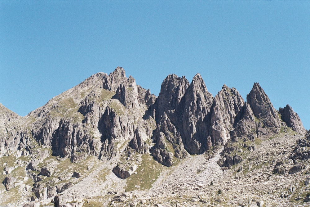 a rocky mountain with a blue sky