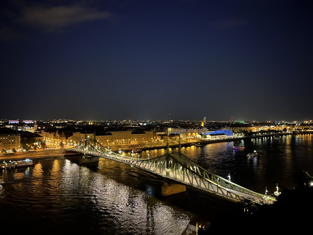 a bridge over a river with a city in the background