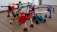 A group of colorful, articulated robot figures made from interlocking plastic pieces is arranged on a wooden floor. Each figure features distinct colors and shapes, with some resembling vehicles or animals equipped with mechanical limbs. The scene is playful and dynamic, showcasing a variety of textures and designs.
