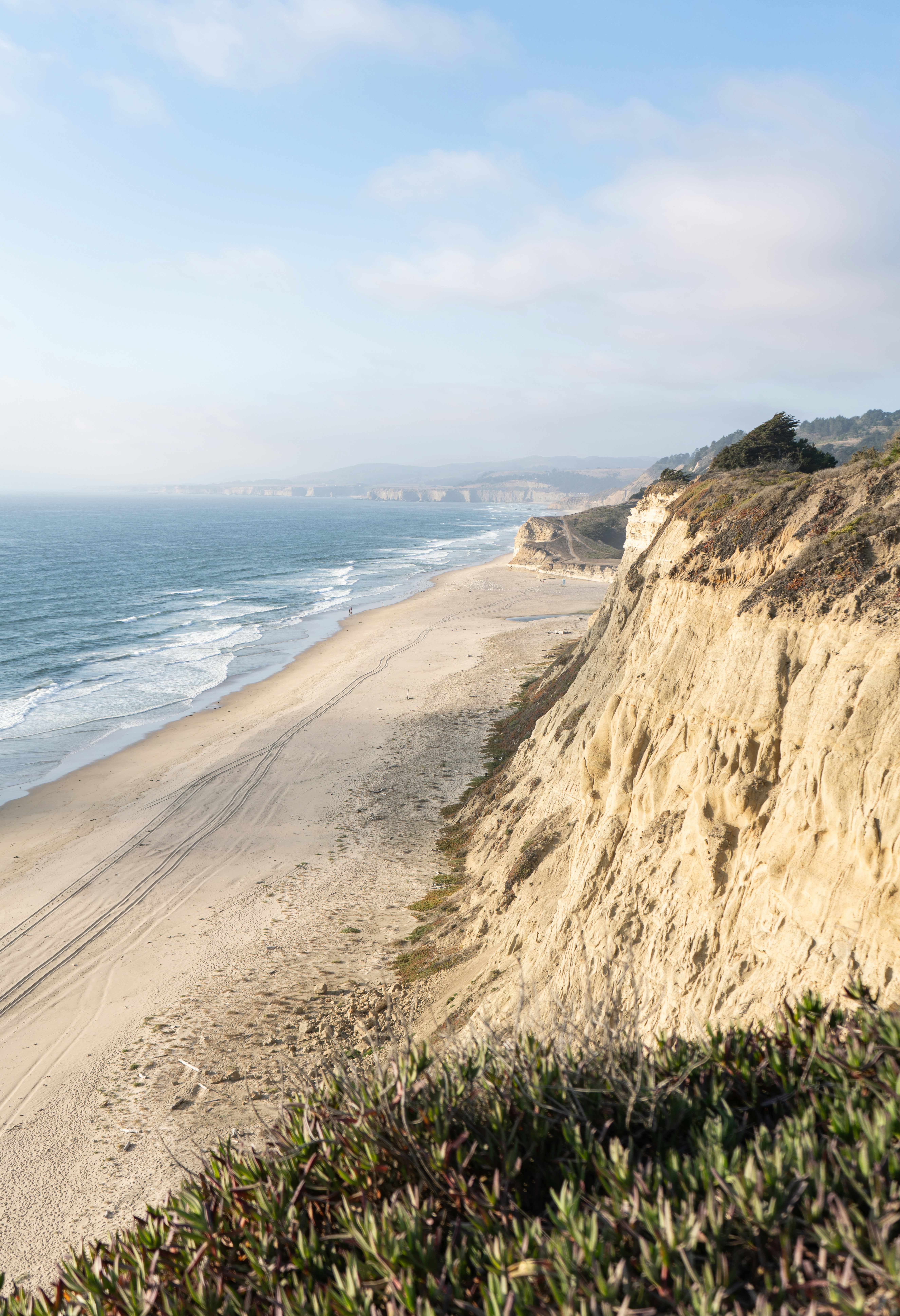 a sandy beach with a body of water in the background