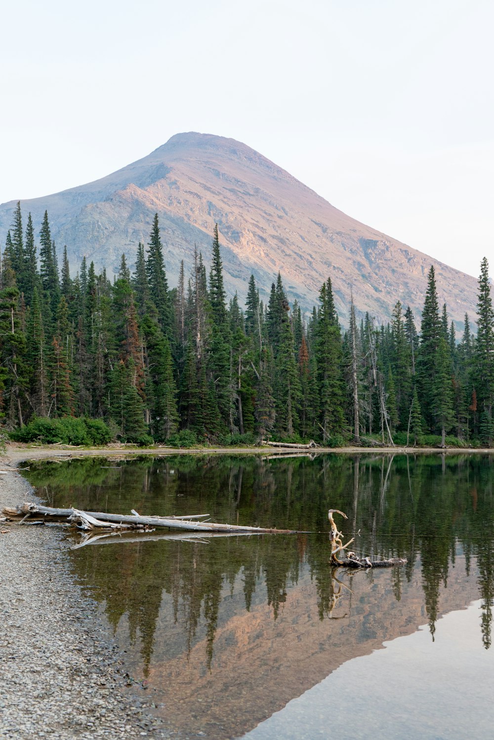 a lake with trees and mountains in the background