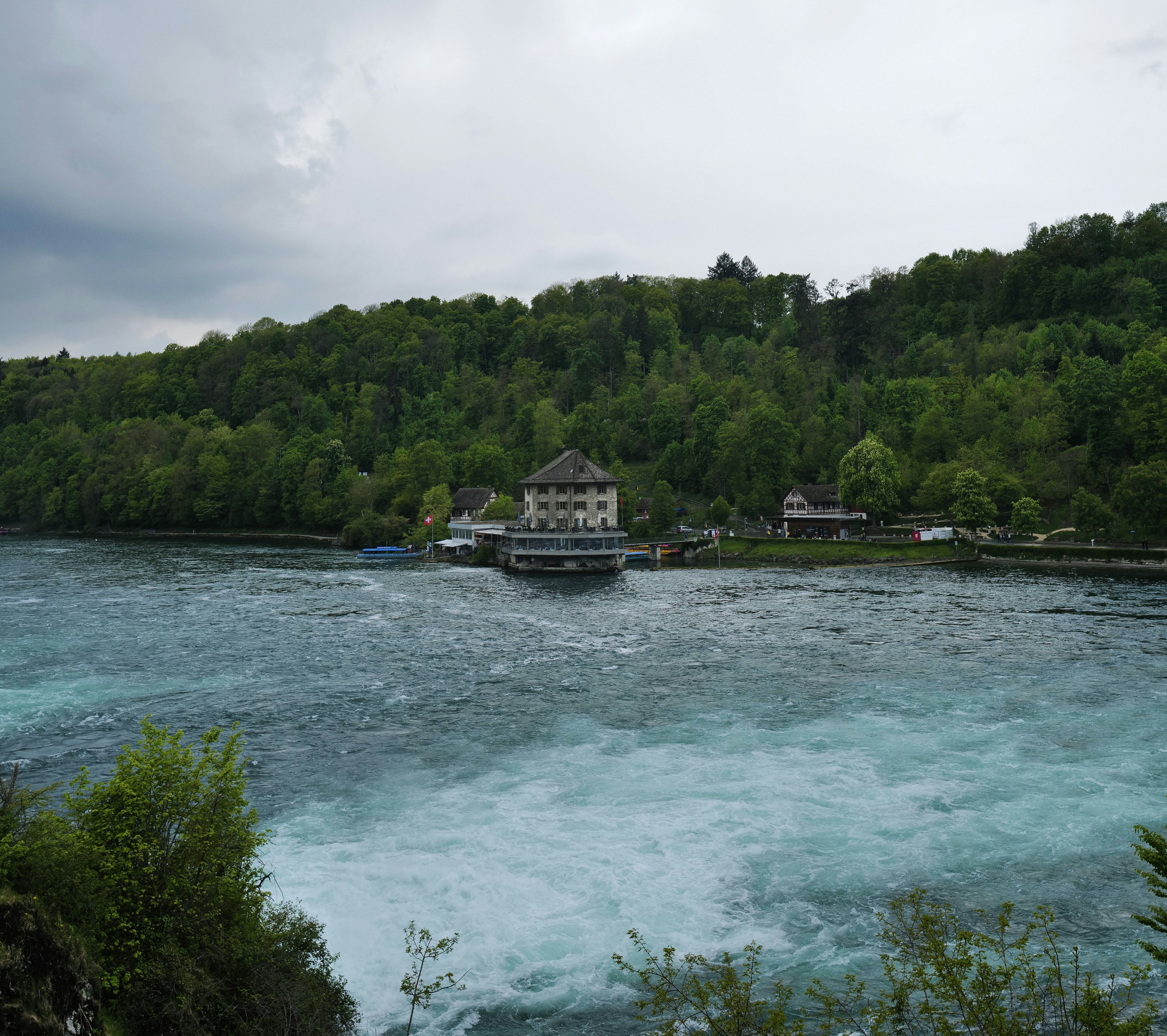 a house on a dock by a lake with trees in the background