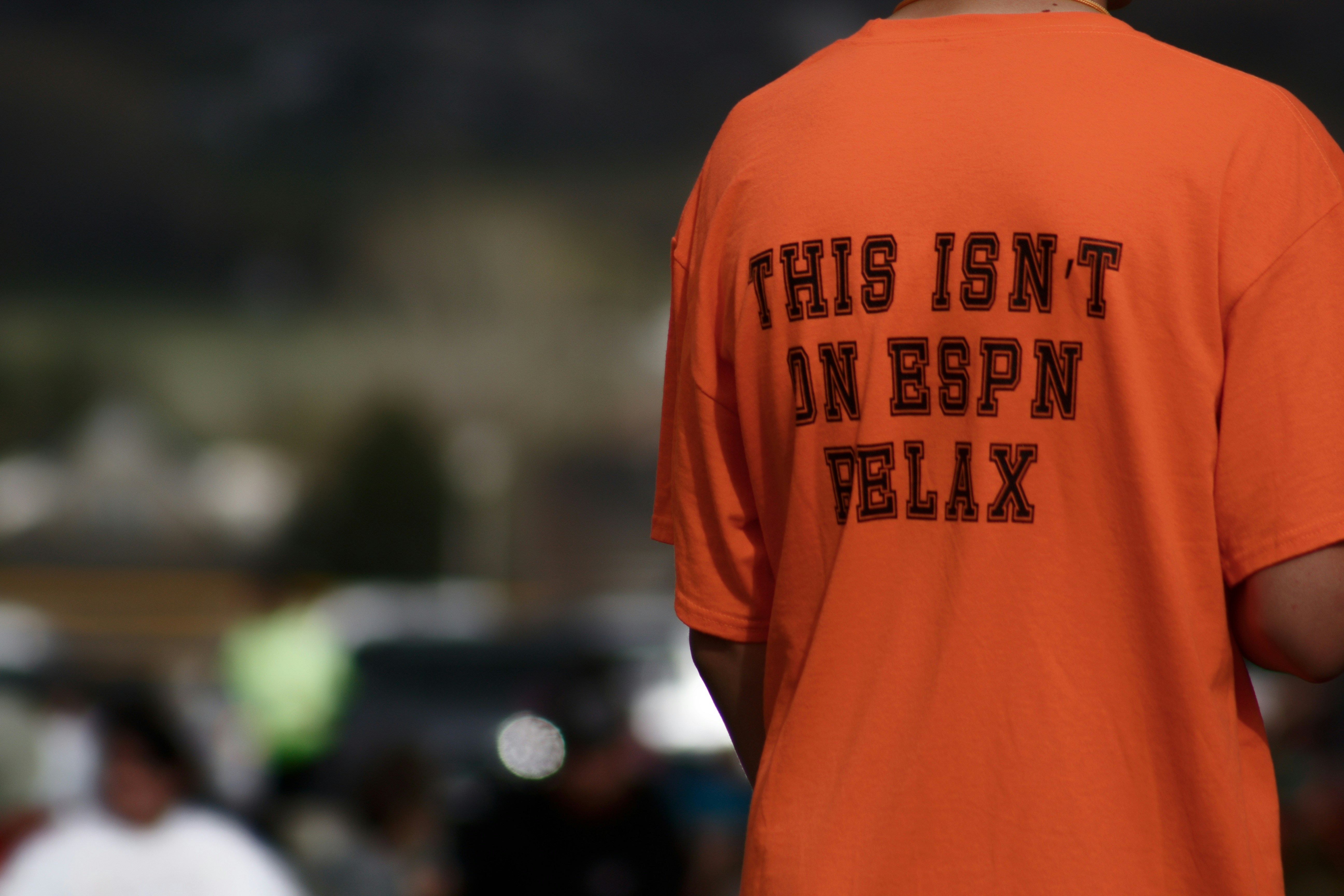 a person wearing an orange shirt with black text on it