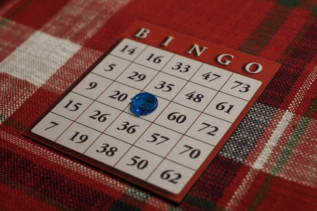 Bingo card with blue dauber marking the center square on a red plaid background.