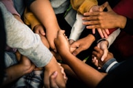 A group of diverse professionals shaking hands in a modern office setting, symbolizing partnership.