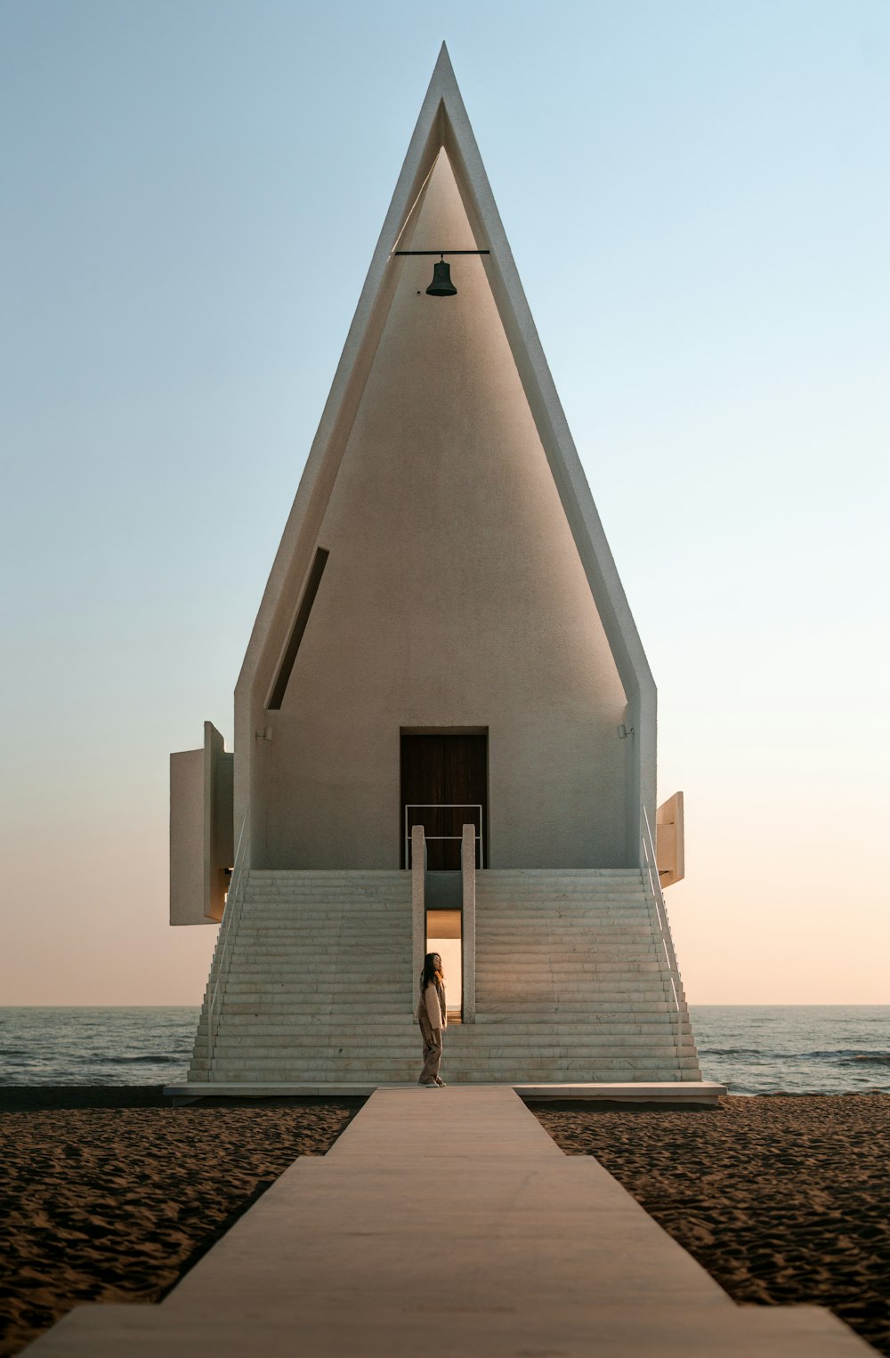 a person standing in front of a large white building