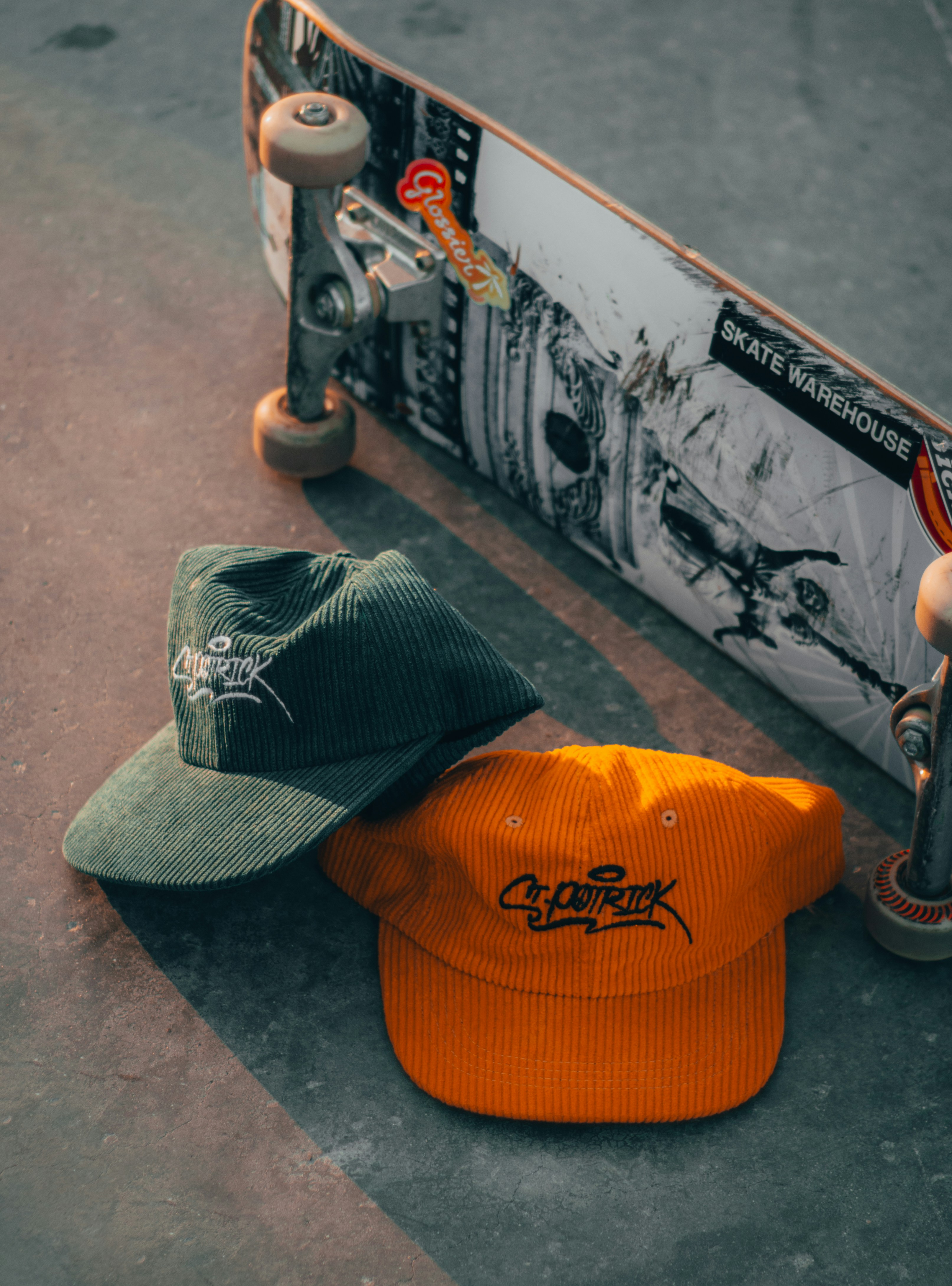 a skateboarder lays on the ground next to a hat