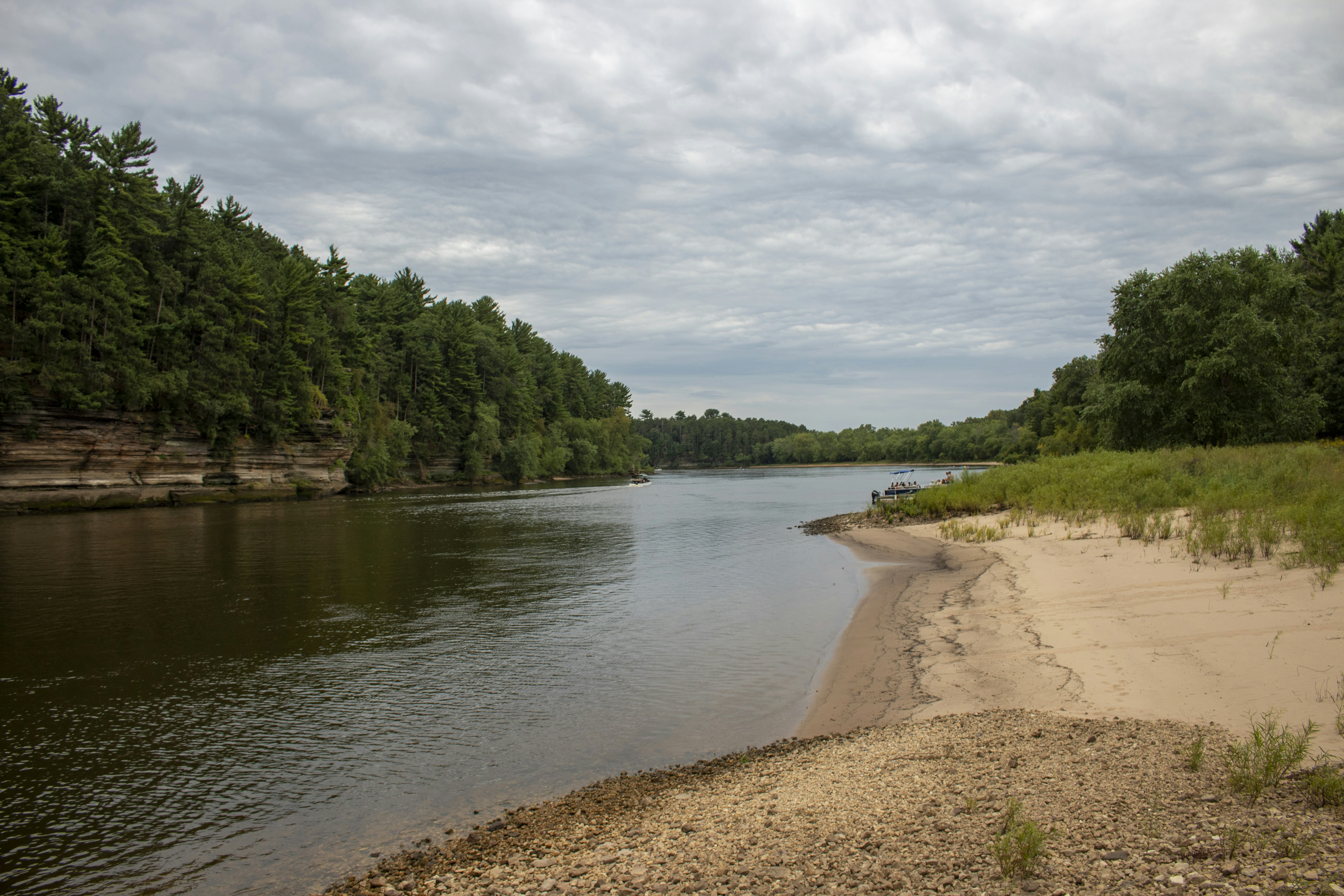 a river with a beach and trees