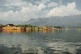 A scenic view of the Dal Lake with houseboats and mountains.