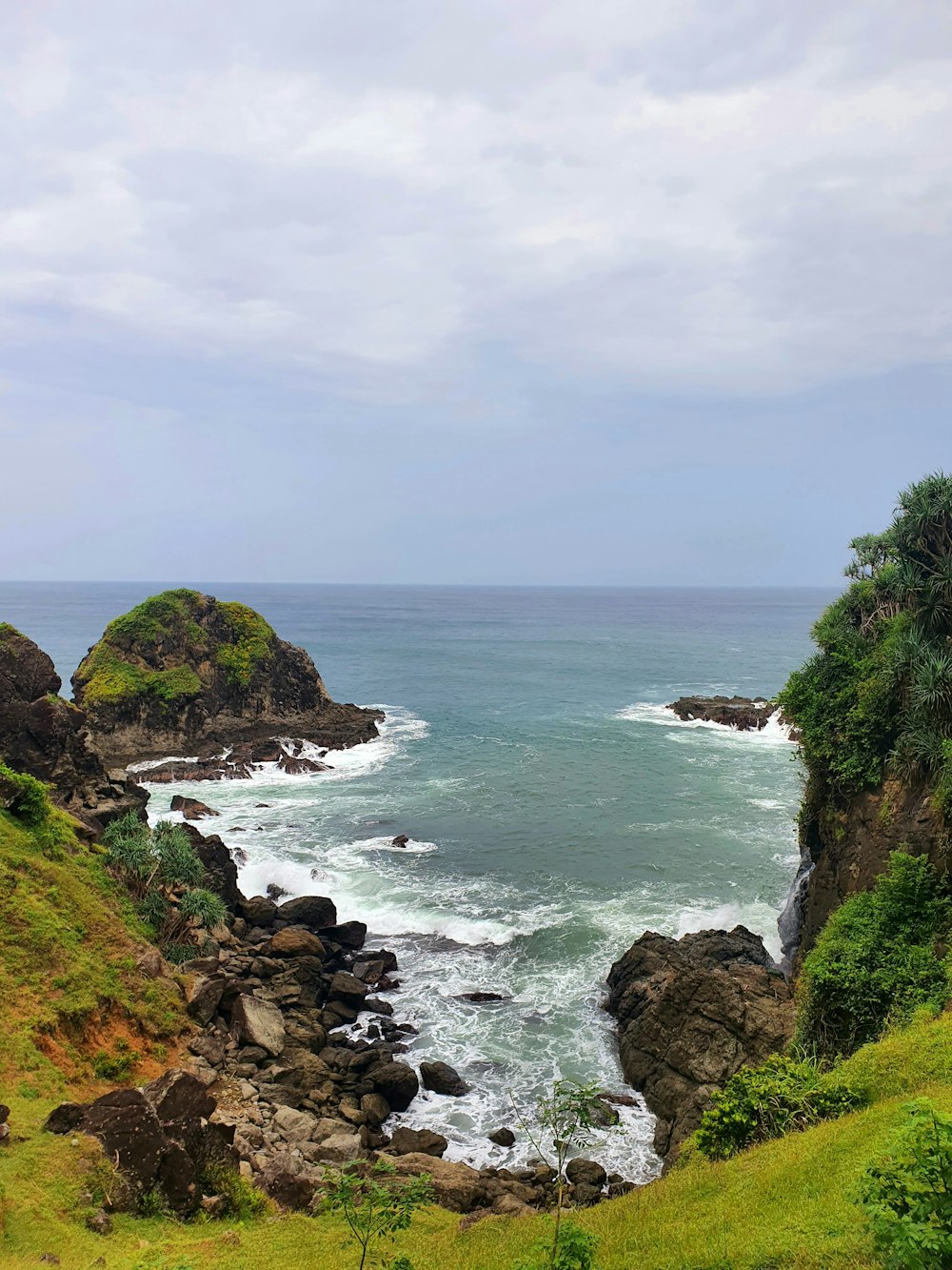 a rocky beach with a body of water in the background