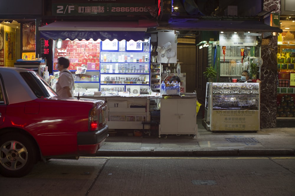 a red car parked in front of a storefront