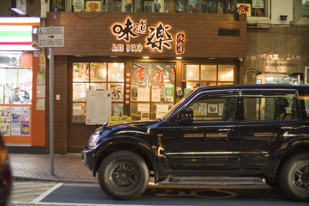 a black car parked in front of a store