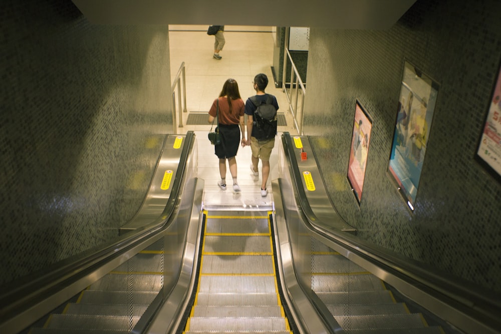 a man and woman walking down a flight of stairs