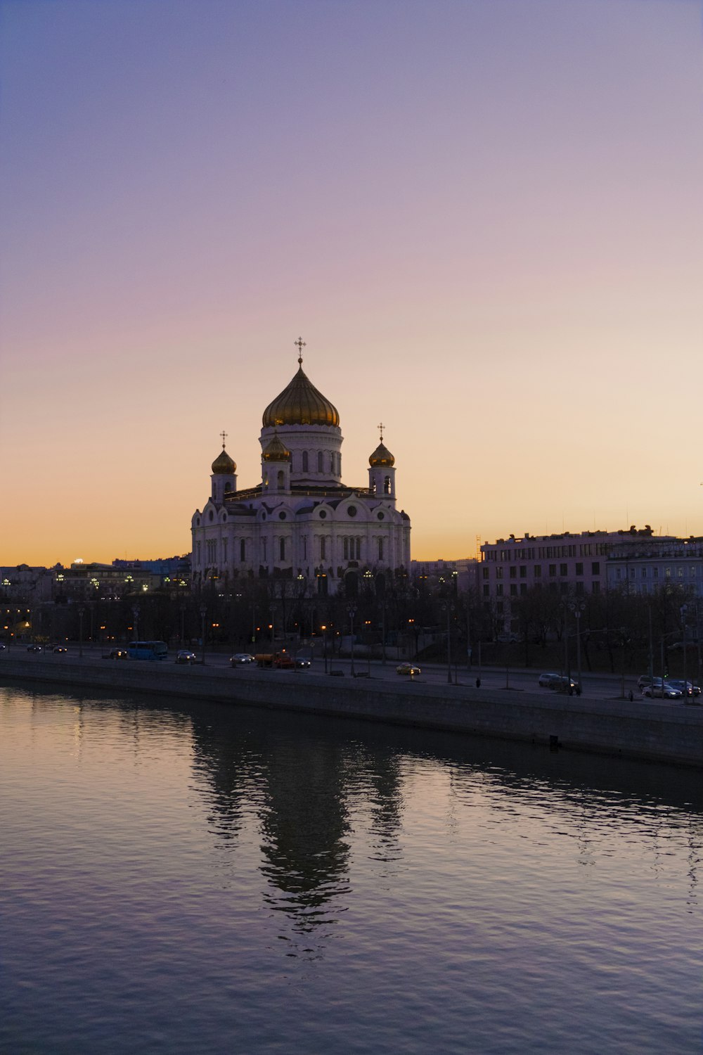 a large building with a domed roof by a body of water