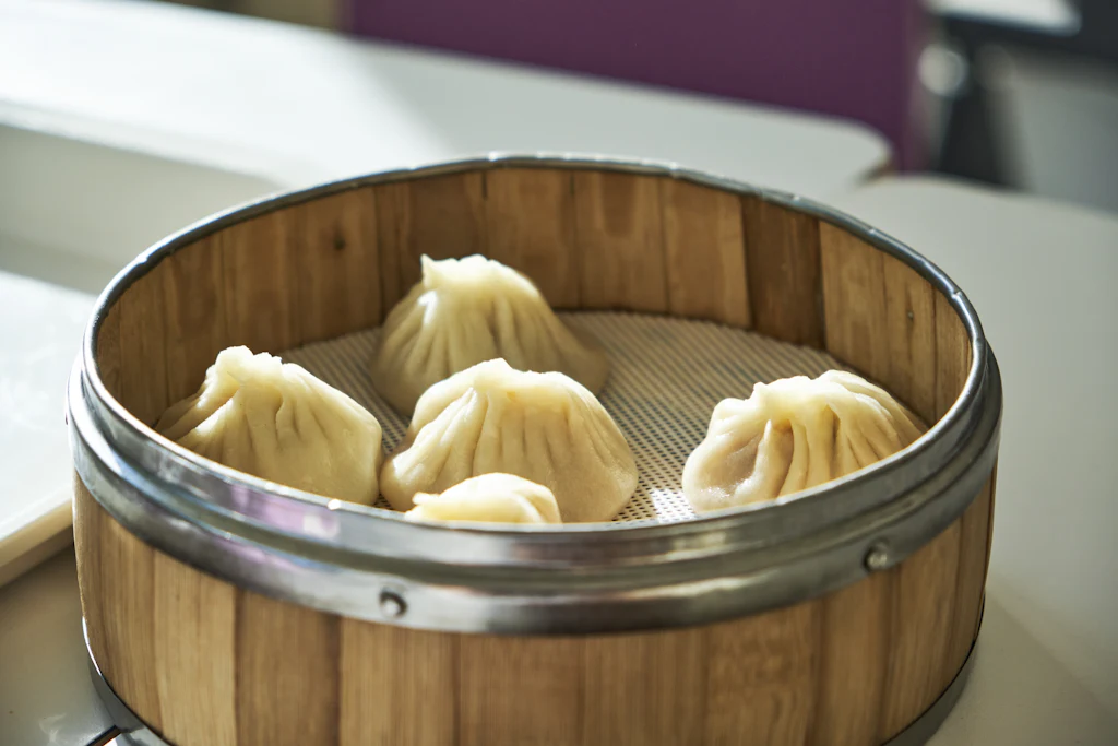 Freshly steamed Chinese dumplings in a round bamboo steamer