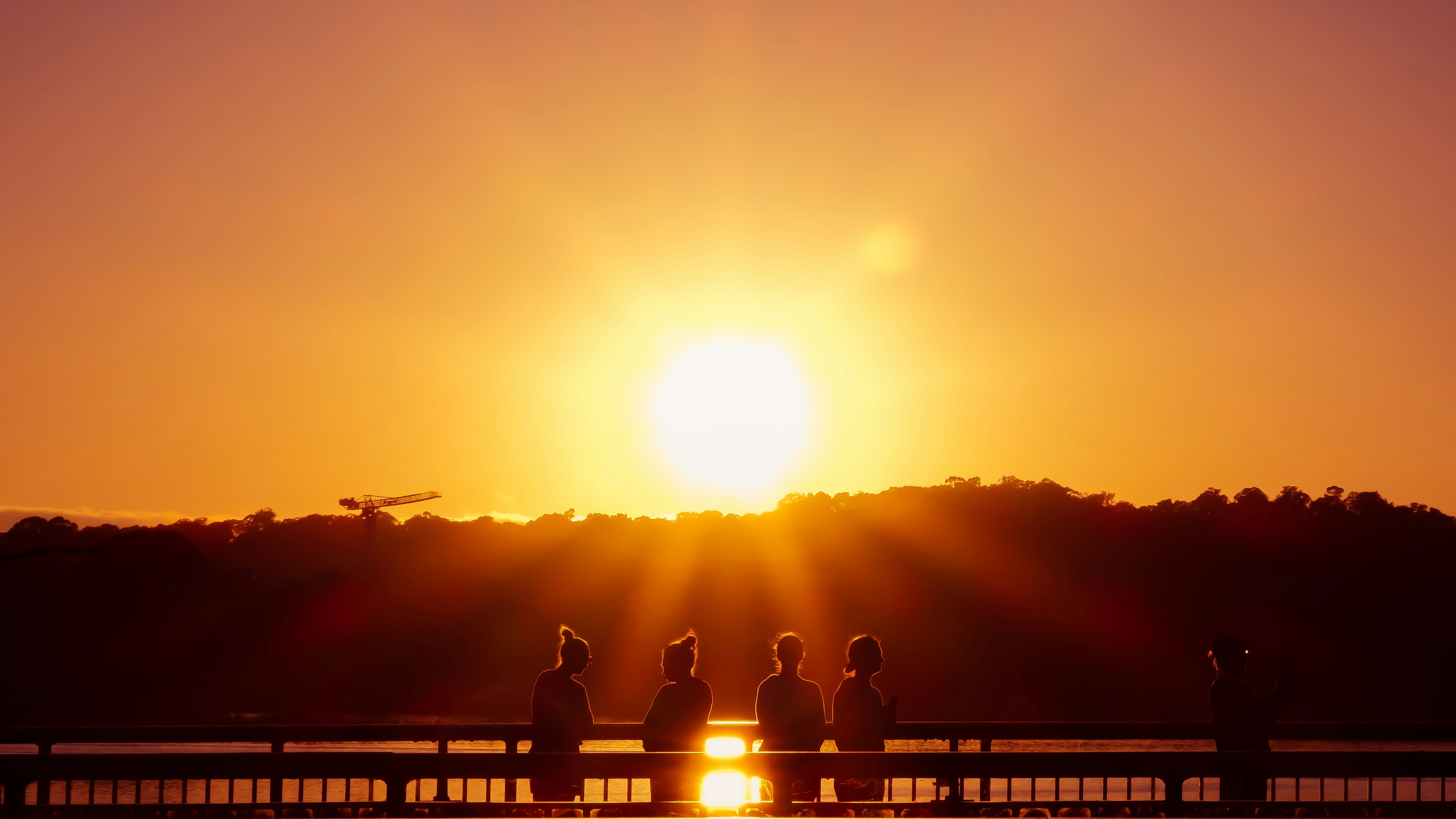 Un grupo de personas sentadas en un banco mirando al sol