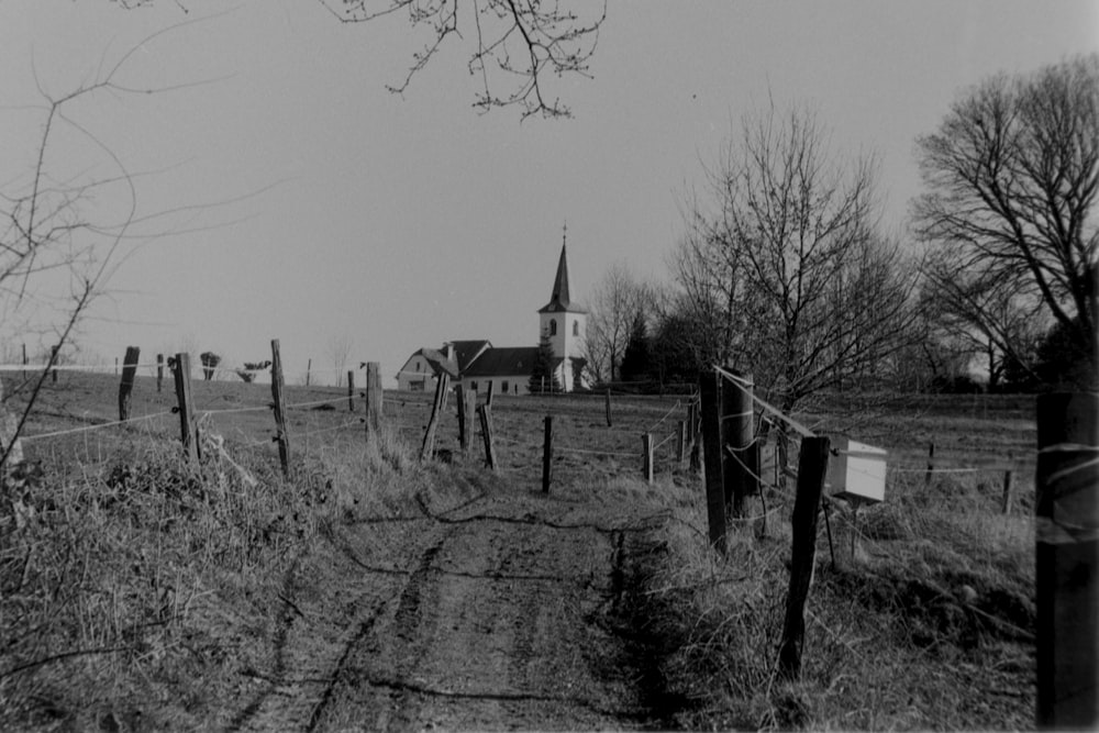 a fenced in field with a church in the background