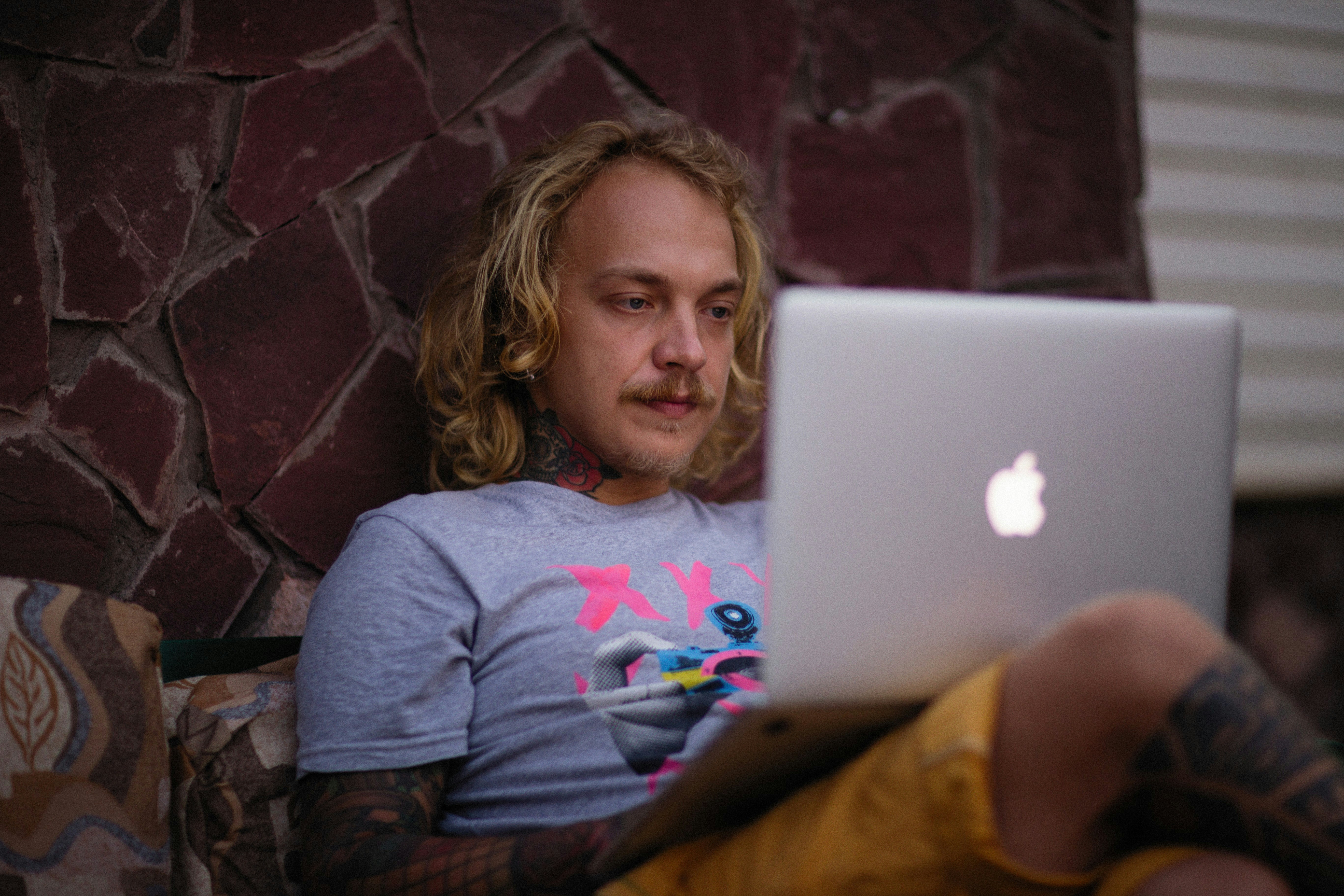 eine Person, die mit einem Laptop auf einer Couch sitzt