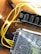 A close-up view of electronic components including a power distribution board labeled 'Moraydular Power Bus Wide V1' and a metal perforated cover. Yellow wires are connected to various terminals, lying on a wooden surface.
