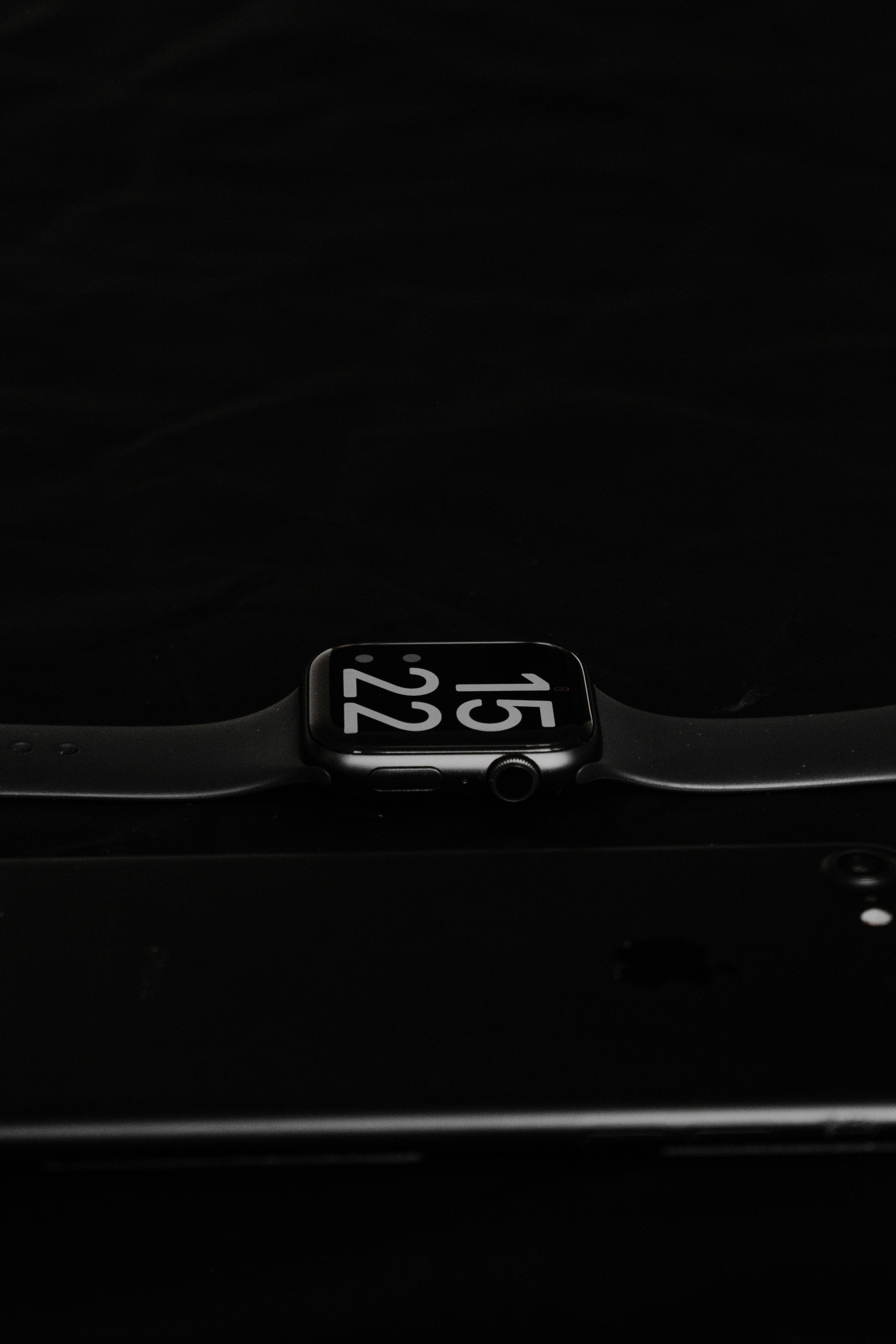 Black smartwatch with round display on dark surface