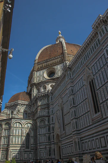 The majestic façade of Duomo di Milano under a bright blue sky.