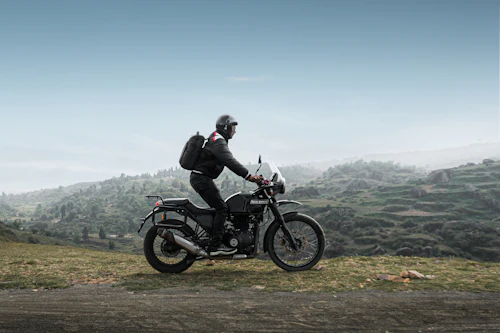 Rider on a motorcycle traveling through a Himalayan mountain landscape